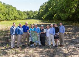 The design and development team onsite at Holliday Farms in front of future fairways.